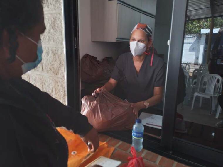 Entrega de un mercado a una persona beneficiaria