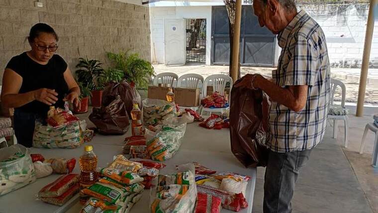 Voluntarios preparando mercados sobre una mesa